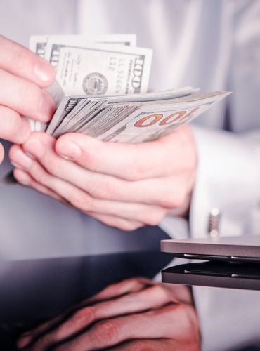 Banker Counting Cash Money. Caucasian Bank Worker with Dollar Banknotes in Hands. Closeup Photo.